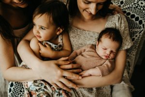 Close up family portrait with a toddler and newborn